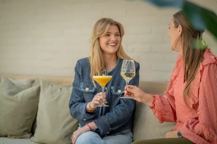 Twee vrouwen proosten met cocktails