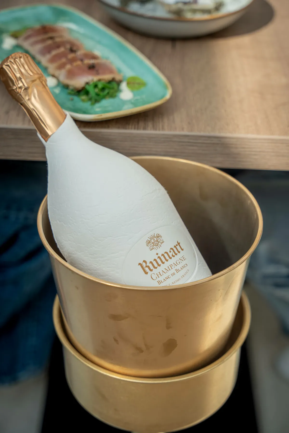 Een fles Ruinart in de gouden koeler