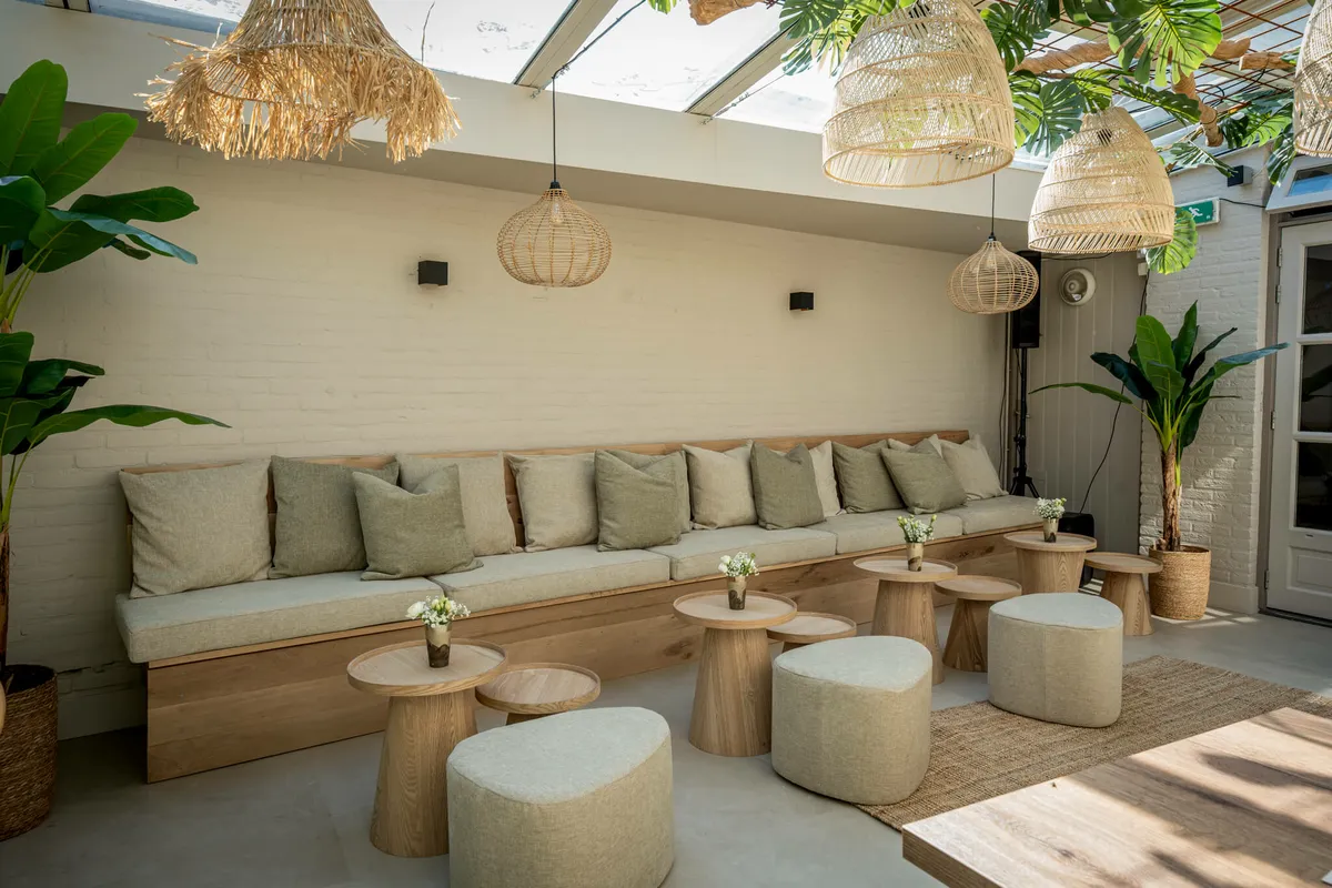 De lounge van Blend met rotan lampen, banken en lage tafels