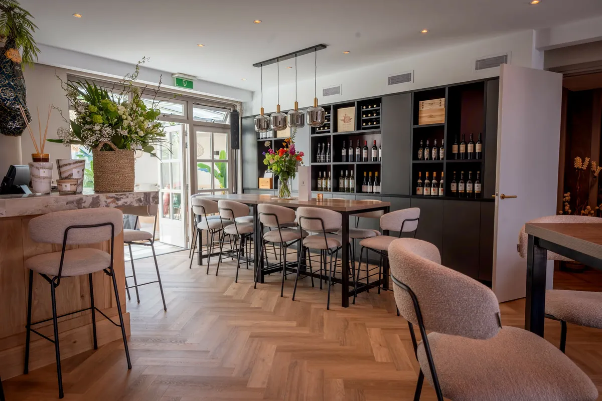 De bar van Blend met de wijnkast, verse bloemen en de visgraatvloer