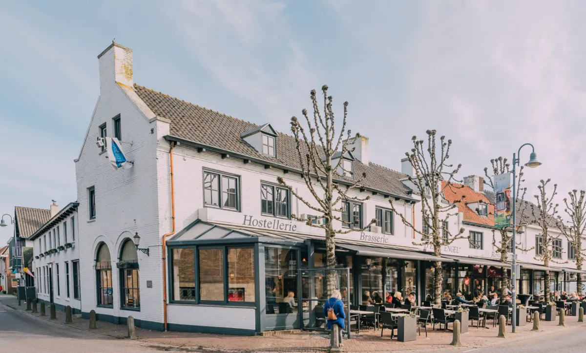 Een wit pand met terras aan een straat in Baarle-Nassau