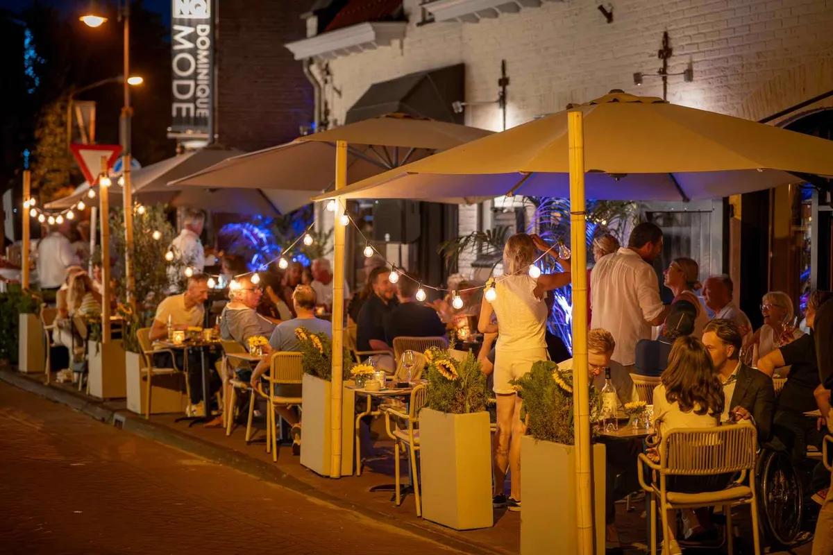 De gevel van Blend met het volle terras in de avond